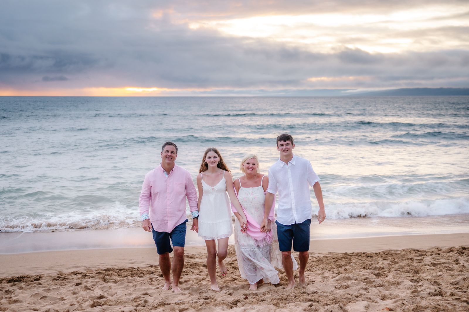 Family walking on the beach at sunset
