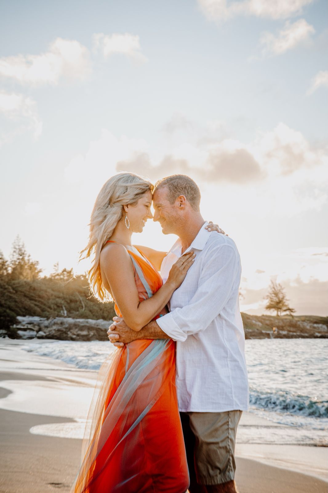 Couple embracing at golden hour on Maui beach